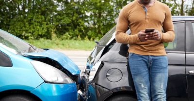 a man leans on his car after an accident | Fuller and Fuller, Attorneys PLLC