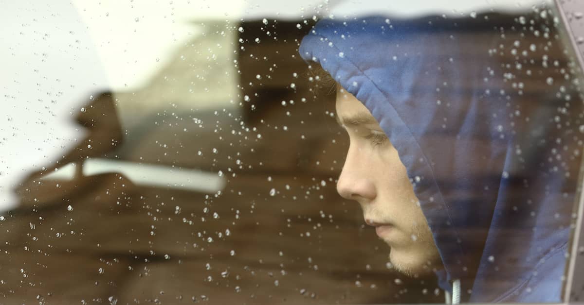 a teen boy sits behind a wet car window | Fuller and Fuller, Attorneys PLLC