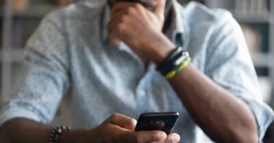 man looking at phone and wondering, 
